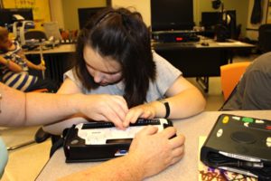 Photo of a student working with braille technology