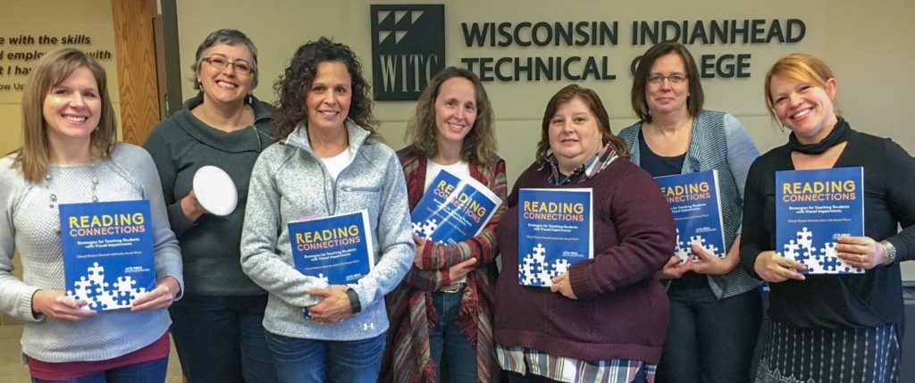 Group of TVI's and O&M's holding the book, "Reading Connections"