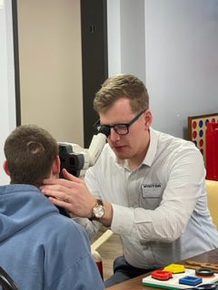 Optometrist using an autorefractor with a student